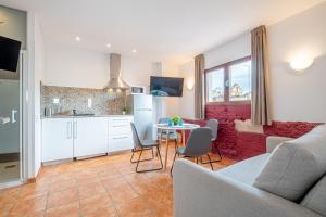 a kitchen and a living room with a table and chairs at Apartamento 2 en la muralla romana junto a la Catedral in Tarragona