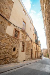 een oud stenen gebouw aan de straatkant bij Apartamento 2 en la muralla romana junto a la Catedral in Tarragona