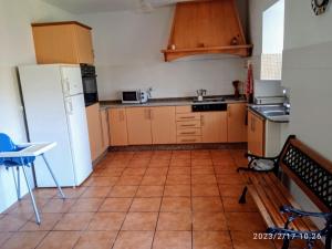 a kitchen with a white refrigerator and a tile floor at Casa Rural O Rabadan in Cedeira