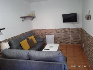 a living room with a blue couch and a tv at Casa Rural O Rabadan in Cedeira