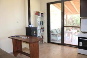 sala de estar con mesa de madera y puerta corredera de cristal en VANGELIS-Triopetra, en Triopetra
