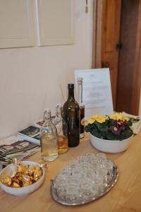 uma mesa de madeira com dois pratos e garrafas de vinho em Apartments Možinetova hiša em Šentjošt nad Horjulom