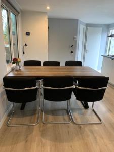 een conferentieruimte met een houten tafel en stoelen bij Het Berkenhuisje in Putten, huisje op de Veluwe in Putten