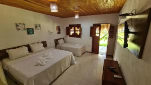 1 dormitorio con 2 camas en una habitación con en Pousada e Restaurante Encanto das Águas, en São Miguel dos Milagres