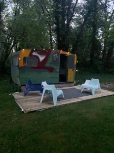 a trailer with two white chairs on a wooden deck at Domaine de la Jarrige in Saint-Vaury