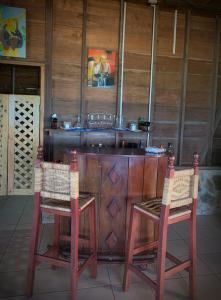 uma cozinha com 2 cadeiras, uma mesa e um lavatório em Sunset Bay B&B em Ilhas do Milho