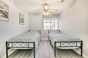 two beds in a room with a ceiling fan at Chandler Home with Yard and Grill 3 Mi to Downtown! in Chandler