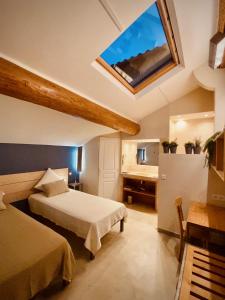 Un dormitorio con dos camas y una claraboya. en L'atelier B&B, en Bédoin