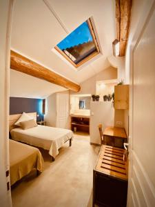 pokój hotelowy z 2 łóżkami i oknem dachowym w obiekcie L'atelier B&B w mieście Bédoin