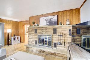 een stenen open haard in een woonkamer met houten muren bij Cozy Wisconsin Abode Walk to Lake Michigan! in Algoma