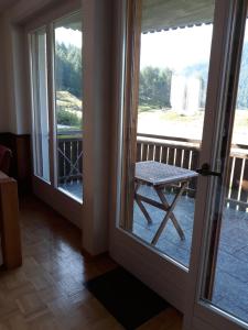 a door leading to a patio with a table on a balcony at Lovely 3 Bedroom Apt. in Maloja