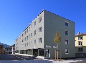 un grand bâtiment blanc avec une chambre d'hôtel dans l'établissement Hotel Flawil, à Flawil