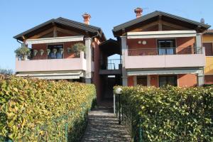 a house with two balconies and a hedge at CASA VACANZE DA RIKI in Peschiera del Garda