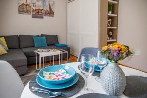 a living room with a table with plates and glasses at Central Luxury apartment in Novi Sad