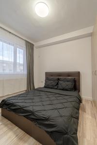 um quarto com uma cama com um edredão preto e uma janela em Hera's Modern Home em Arad