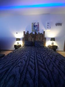 ein großes Bett in einem Zimmer mit zwei Lampen in der Unterkunft Loft Spa Led & bo in Thaon-les-Vosges