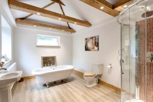 a bathroom with a tub and a toilet and a sink at The Grove Cromer in Cromer