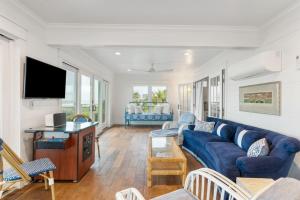 a living room with a blue couch and a tv at 1001 E Arctic Out of the Blue Stunning Oceanfront Home in Folly Beach