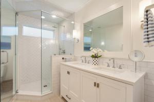 a white bathroom with a sink and a shower at 1001 E Arctic Out of the Blue Stunning Oceanfront Home in Folly Beach