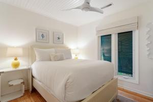a white bedroom with a bed and a window at 1001 E Arctic Out of the Blue Stunning Oceanfront Home in Folly Beach