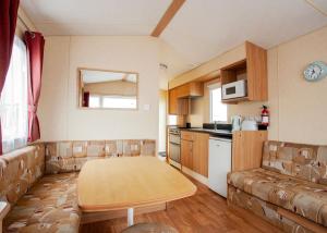 a living room with a table and a couch at Eastern Beach Caravan Park in Caister-on-Sea