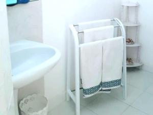 Baño blanco con toallero junto a un lavabo en SARA HOUSE NADOR en Nador