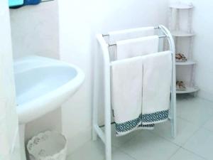 a white bathroom with a towel rack next to a sink at SARA HOUSE NADOR in Nador +52 photos
