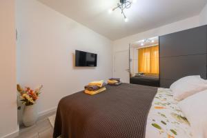 a bedroom with a bed and a tv on the wall at Apartment Aida in Sarajevo