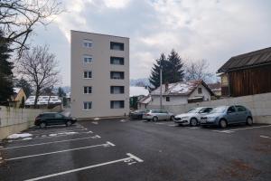 a parking lot with cars parked in front of a building at Apartment Aida in Sarajevo