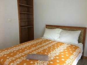 a bedroom with a bed with a pillow and a book shelf at Pension Te Aroha - Te Rai in Maatea