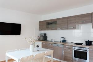 a kitchen with a white table and a tv on the wall at T&K Apartments - 3 Room Apartment in Mülheim an der Ruhr +7 photos