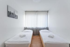 twee bedden in een kamer met een raam bij T&K Apartments - 3 Room Apartment in Mülheim an der Ruhr