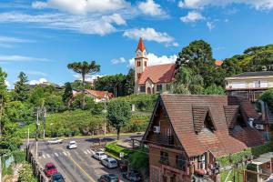 una iglesia con una torre de reloj en la cima de una ciudad en Solar da Encosta - Stay House Temporada, en Gramado