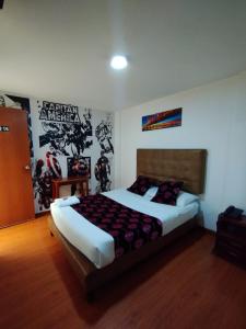 a bedroom with a bed with a poster on the wall at Hotel COMIC CITY in Bogotá
