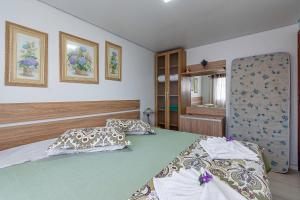 um quarto com 2 camas e um espelho em Solar da Encosta - Stay House Temporada em Gramado