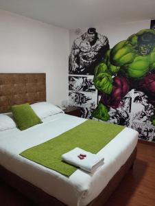 1 dormitorio con 2 camas y un mural de superhéroes en la pared en Hotel COMIC CITY, en Bogotá