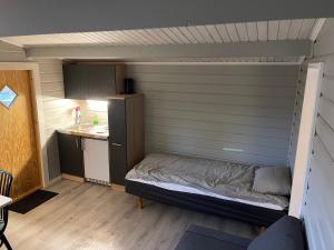 mały pokój z łóżkiem i kuchnią w obiekcie Kvarnsjöns Naturcamping w mieście Sjötofta