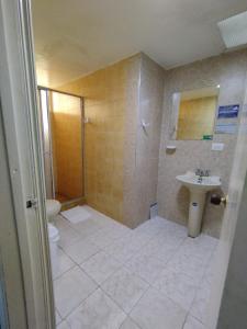 Un baño con ducha, lavabo e inodoro. en Hotel COMIC CITY, en Bogotá