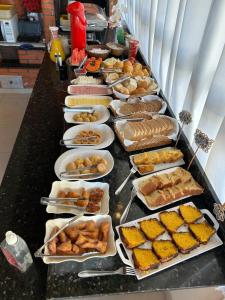 a buffet with many plates of food on a table at Pousada Rosália in Penha