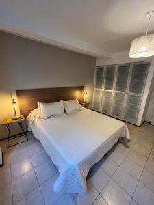 1 dormitorio con 1 cama blanca grande en una habitación en Departamentos del Sol para 4 personas Reciclado a Nuevo en Mendoza
