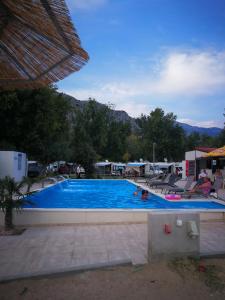 a large blue swimming pool with chairs and mountains in the background at Apartments Jadra Omiš in Omiš