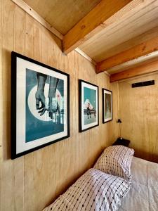 ein Schlafzimmer mit drei Bildern an der Wand und einem Bett in der Unterkunft Molco Cabins Palafito in Pucón