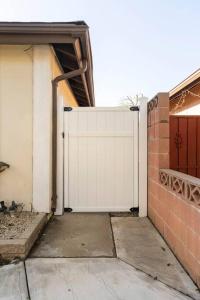 um portão branco para uma casa com garagem em Romantic Coastal Private Room em Oxnard