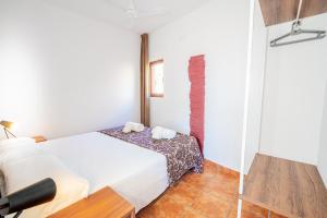 ein Schlafzimmer mit einem weißen Bett mit zwei Handtüchern darauf in der Unterkunft Apartamento 3 en la muralla romana junto a la Catedral in Tarragona