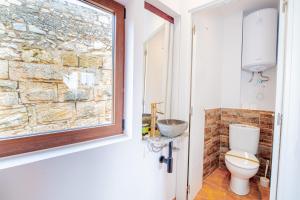 ein Bad mit einem WC und einer Steinmauer in der Unterkunft Apartamento 3 en la muralla romana junto a la Catedral in Tarragona
