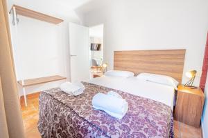 a hotel room with a bed with two towels on it at Apartamento 23 en la muralla romana junto a la Catedral in Tarragona