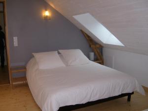 a bedroom with a white bed in a attic at Le Chêne Blanc in Plessé