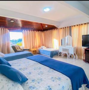 a large bedroom with two beds and a television at Fantasy Buzios in Búzios