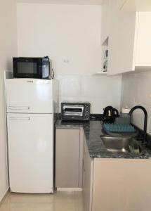 a kitchen with a white refrigerator and a microwave at BL CALLE CATAMARCA in Corrientes