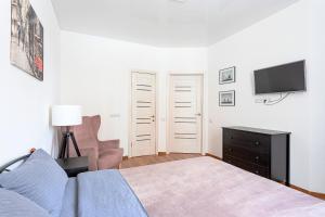 a bedroom with a bed and a tv and a chair at 054 квартира ЖК Софія Резиденс, 1 поверх in Kyiv